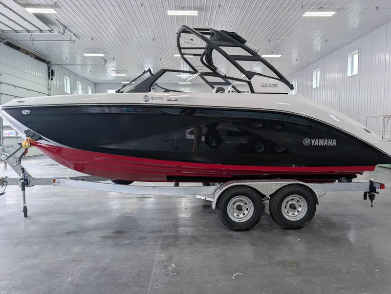 Slide: The Image of 2025 Yamaha Boats 222SE on trailer in a spacious indoor facility. - 7