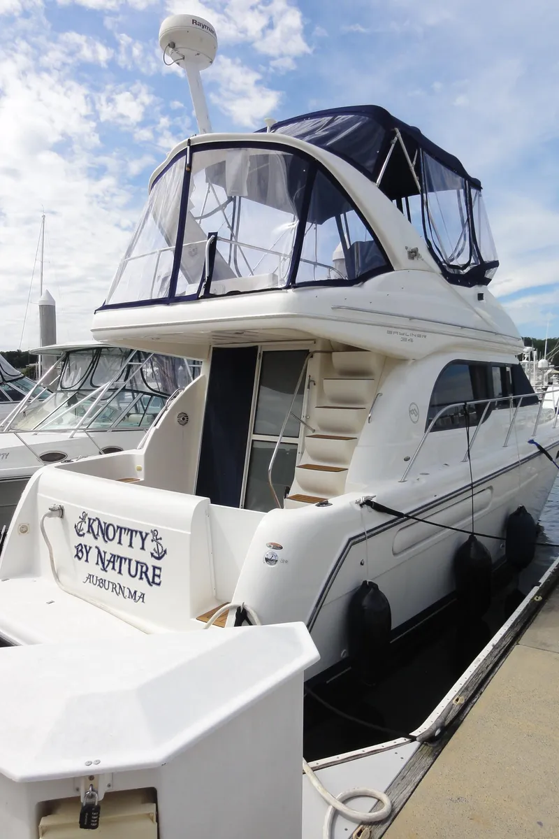 The Image of 2001 Bayliner 3488 Command Bridge Motoryacht docked at marina, featuring upper deck and cabin. - 0