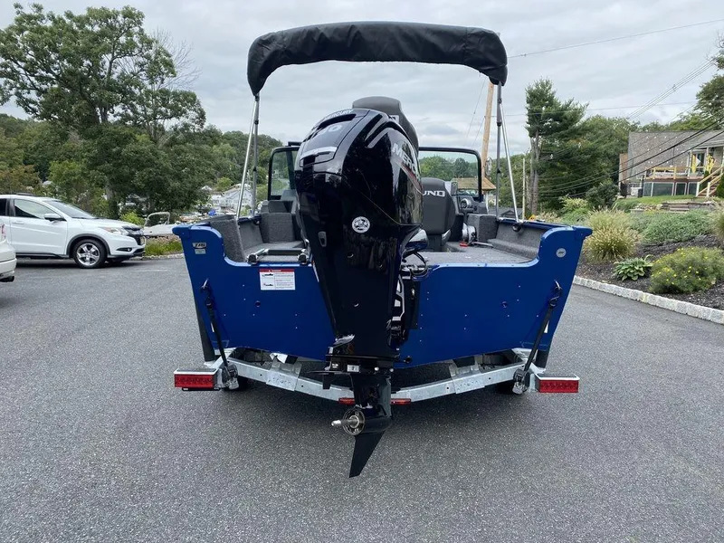 Slide: The Image of 2025 Lund 1650 Rebel XL boat with outboard motor, parked on a driveway. - 10