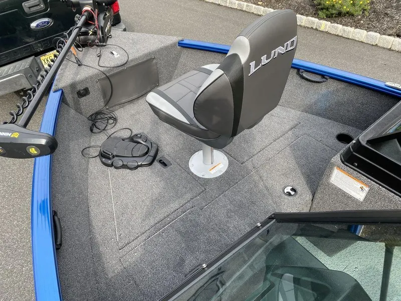 Slide: The Image of 2025 Lund 1650 Rebel XL boat interior with swivel seat and trolling motor. - 7