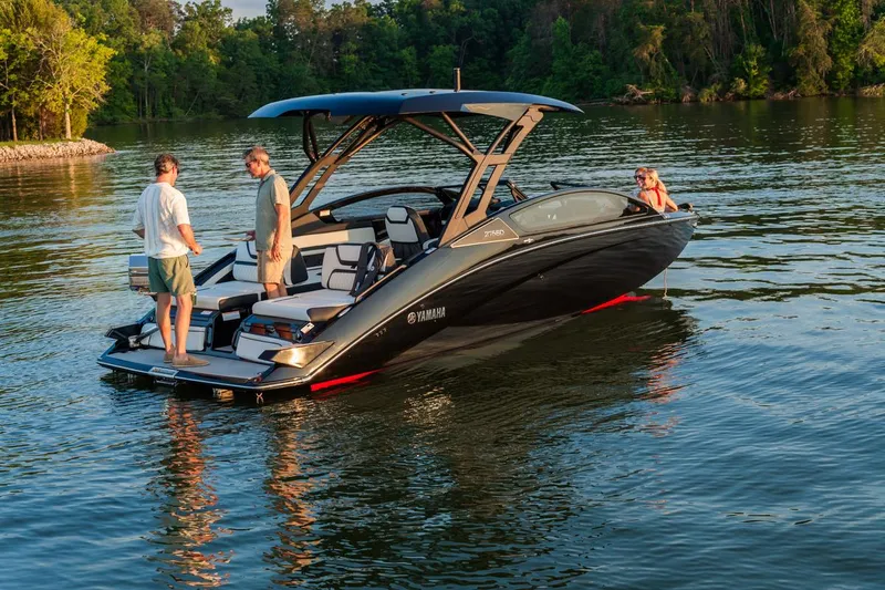 Slide: The Image of 2025 Yamaha Boats 275 SD on a serene lake with passengers enjoying the view. - 2