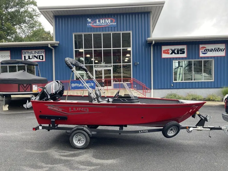 The Image of 2025 Lund 1650 Angler boat in red, parked outside a dealership. - 0