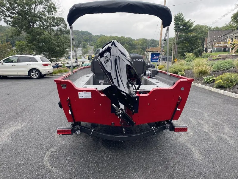 Slide: The Image of 2025 Lund 1650 Angler boat, red exterior, parked on asphalt, rear view. - 8