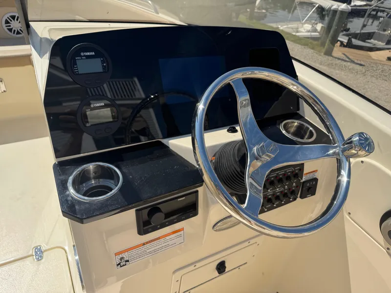 Slide: The Image of 2025 Scout 215 Dorado boat dashboard with steering wheel and Yamaha controls. - 11