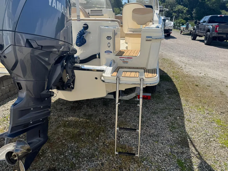 Slide: The Image of 2025 Scout 215 Dorado boat with Yamaha outboard motor and swim ladder on gravel. - 15