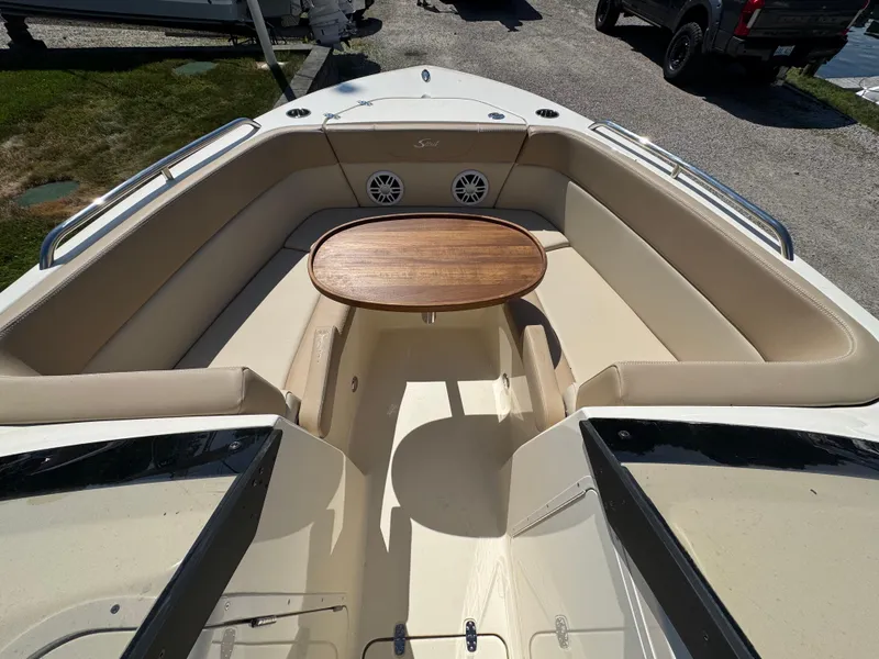 Slide: The Image of 2025 Scout 215 Dorado boat interior with seating and wooden table. - 18