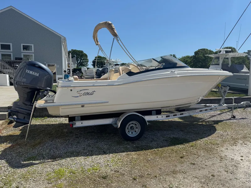 Slide: The Image of 2025 Scout 215 Dorado boat on trailer with Yamaha outboard motor, parked outdoors. - 2