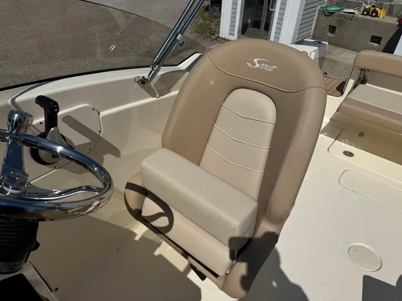 Slide: The Image of 2025 Scout 215 Dorado boat interior with beige captain's seat and steering wheel. - 34