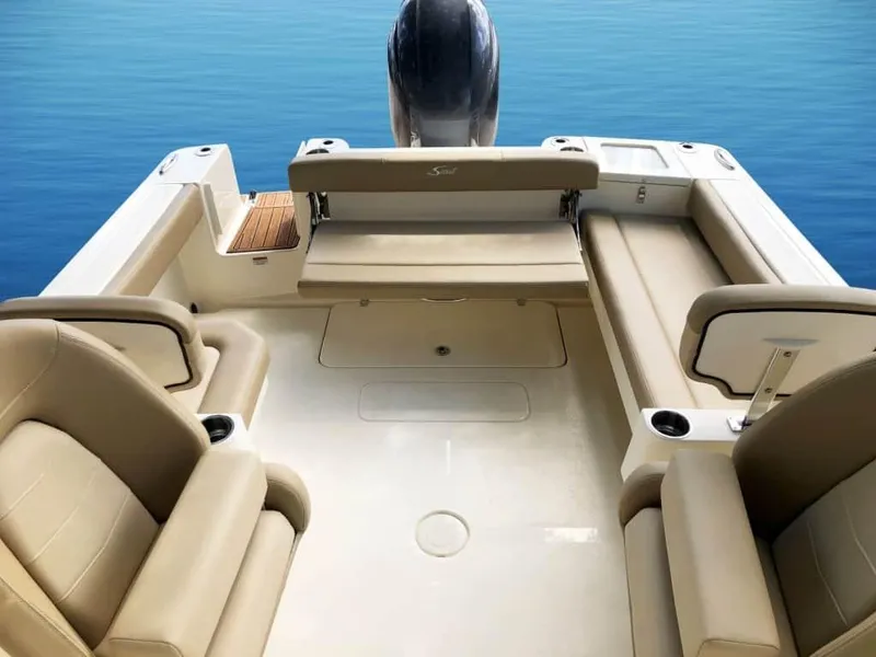 Slide: The Image of 2025 Scout 215 Dorado boat interior with beige seating and sleek design on calm water. - 49
