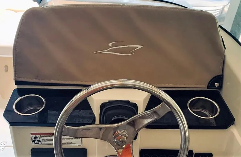 Slide: The Image of 2025 Scout 215 Dorado boat dashboard with steering wheel and cup holders. - 56