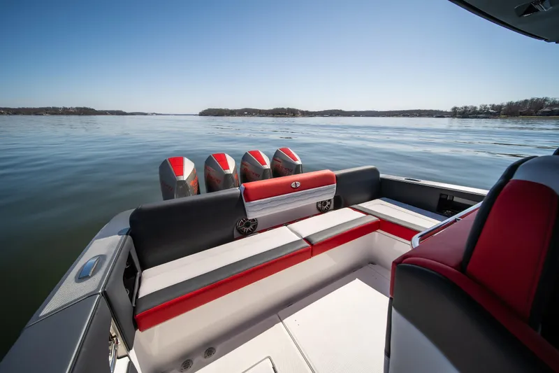 Slide: The Image of 2025 Cigarette 41 Nighthawk boat interior with red and black seating on a calm lake. - 12