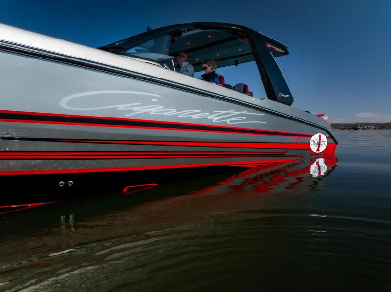 Slide: The Image of 2025 Cigarette 41 Nighthawk boat on calm water, showcasing sleek design and branding. - 2