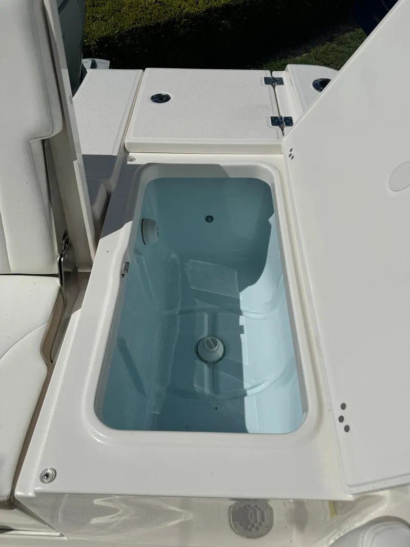 Slide: The Image of 2025 Robalo 266 Cayman SD boat storage compartment with open lid. - 14