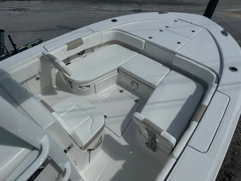 Slide: The Image of 2025 Robalo 266 Cayman SD boat interior with white seating and storage compartments. - 17