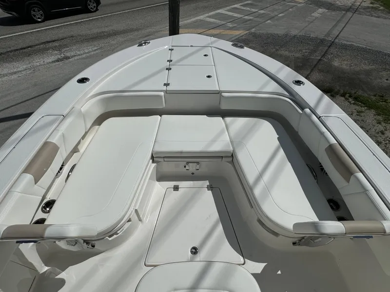Slide: The Image of 2025 Robalo 266 Cayman SD boat interior with white seating and storage compartments. - 18