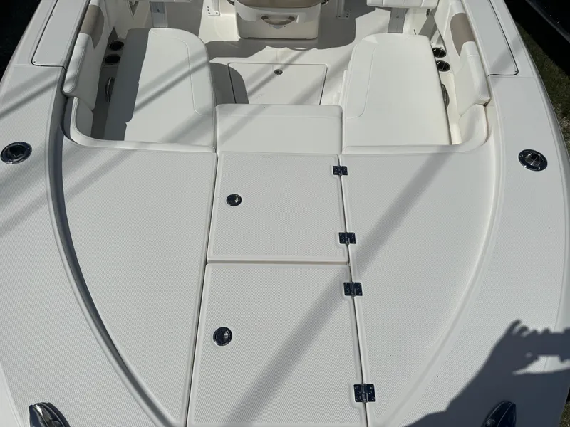 Slide: The Image of 2025 Robalo 266 Cayman SD boat interior with white seating and storage compartments. - 20