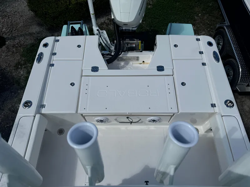 Slide: The Image of 2025 Robalo 266 Cayman SD boat deck with rod holders and storage compartments. - 32