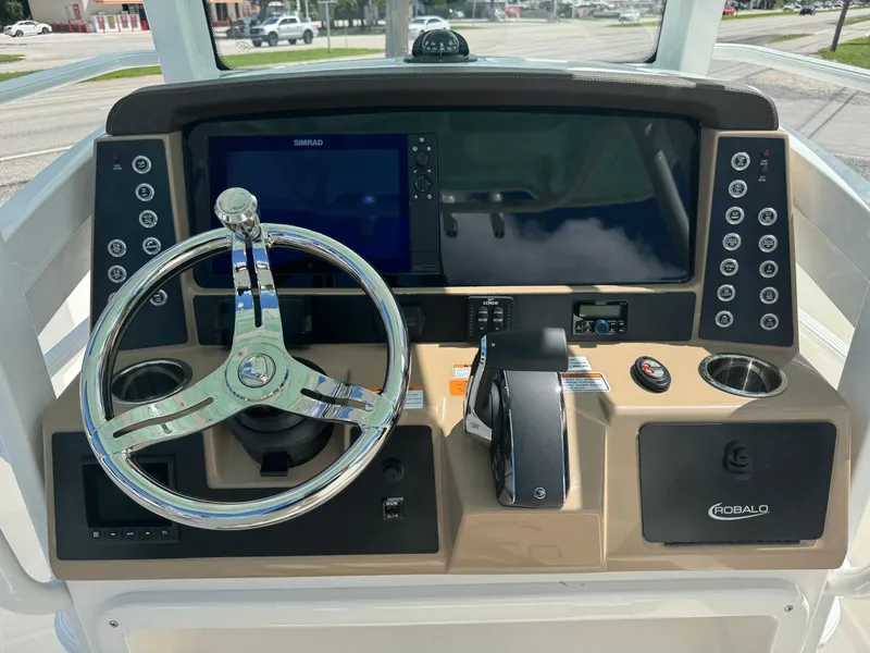 Slide: The Image of 2025 Robalo 266 Cayman SD boat dashboard with steering wheel and control panel. - 9
