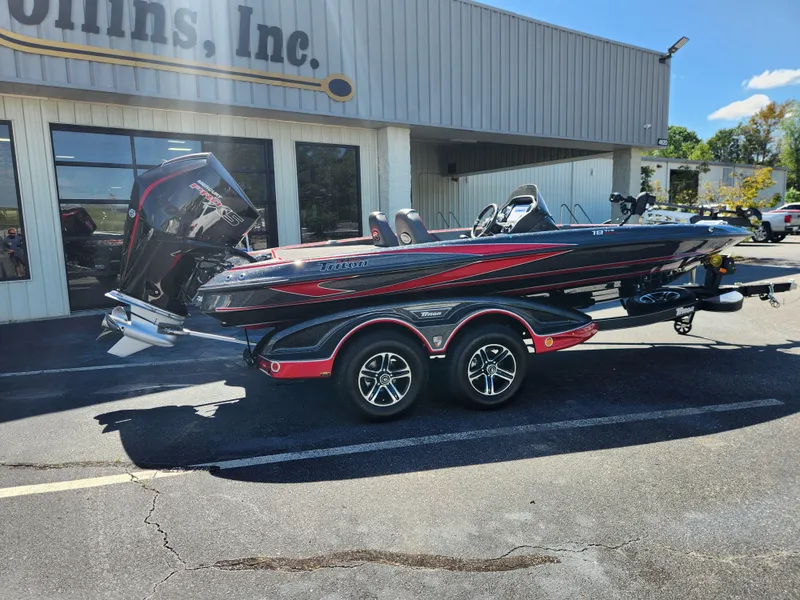 Slide: The Image of 2024 Triton 18 TrX boat with trailer parked outside a building. - 1