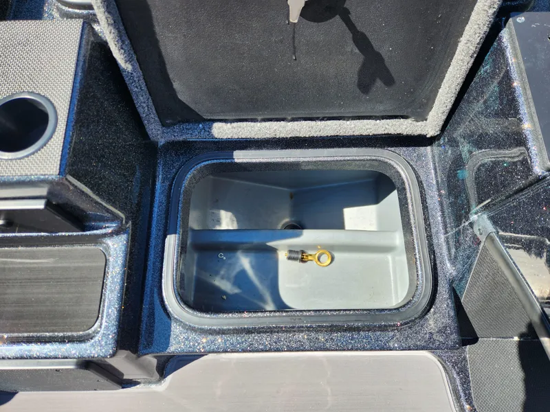 Slide: The Image of 2024 Triton 18 TrX boat storage compartment with key inside. - 12