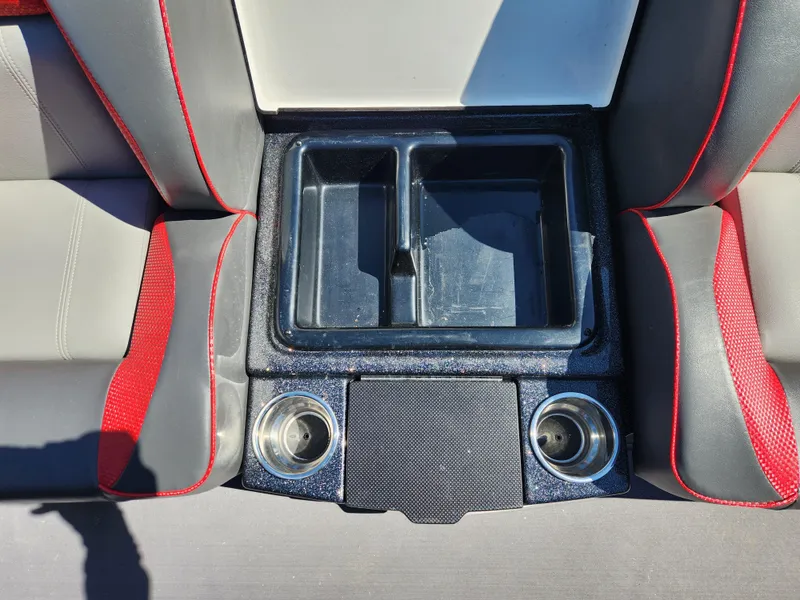 Slide: The Image of 2024 Triton 18 TrX boat interior with cup holders and storage compartment. - 15
