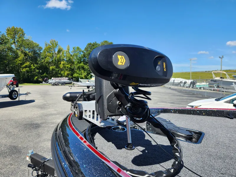 Slide: The Image of 2024 Triton 18 TrX boat with trolling motor in a sunny outdoor setting. - 23