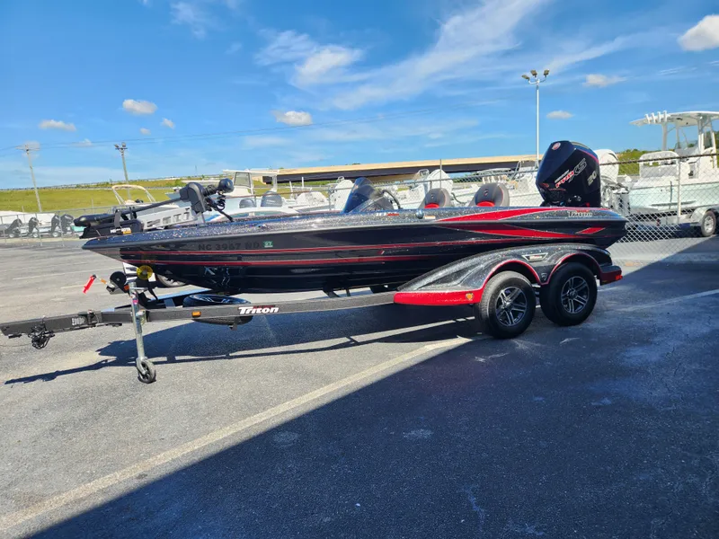 Slide: The Image of 2024 Triton 18 TrX bass boat on trailer, parked outdoors. - 3
