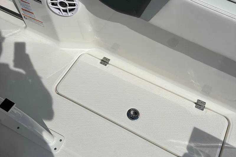 Slide: The Image of 2025 Robalo R250 Center Console boat deck with storage compartment and speaker. - 11