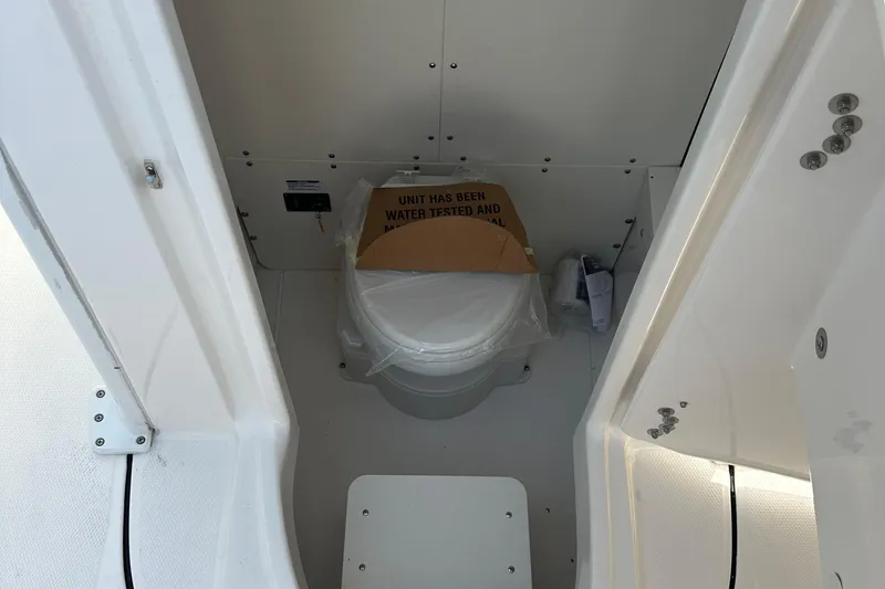 Slide: The Image of 2025 Robalo R250 Center Console boat interior with a covered toilet. - 15