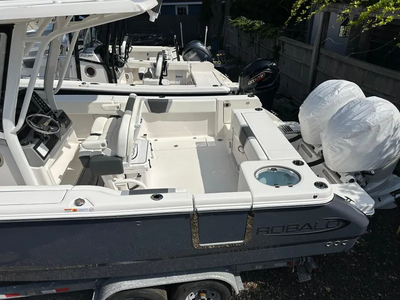 Slide: The Image of 2025 Robalo R250 Center Console boat with dual engines, parked on a trailer. - 2
