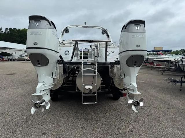 Slide: The Image of 2025 Manitou 27 LX SRS DE boat with dual Suzuki 350 outboard engines, rear view. - 11