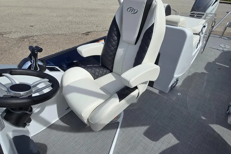 Slide: The Image of Luxurious seating on 2025 Manitou 27 boat with sleek design and modern steering wheel. - 4
