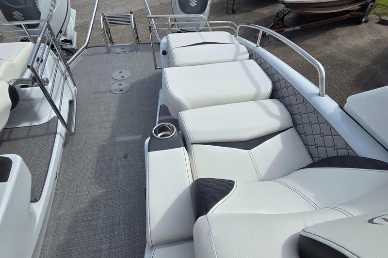 Slide: The Image of 2025 Manitou 27 boat interior with white cushioned seating and stainless steel railings. - 9