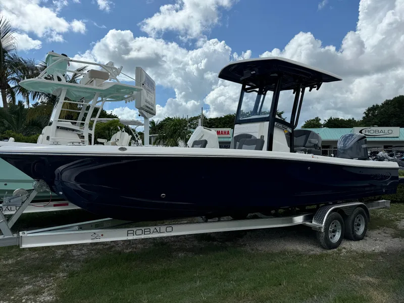 The Image of 2025 Robalo 246 Cayman boat on trailer under cloudy sky. - 1