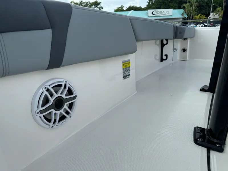 Slide: The Image of 2025 Robalo 246 Cayman boat interior with cushioned seating and speaker system. - 15