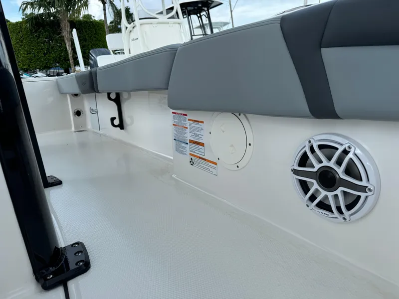 Slide: The Image of 2025 Robalo 246 Cayman boat interior with cushioned seating and speaker system. - 16