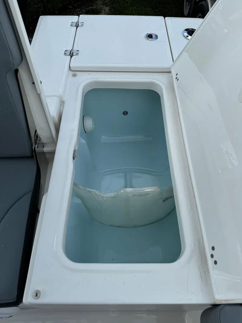 Slide: The Image of 2025 Robalo 246 Cayman boat storage compartment with open lid. - 20