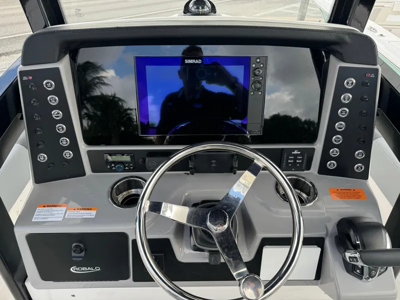 Slide: The Image of 2025 Robalo 246 Cayman boat dashboard with steering wheel and navigation display. - 23