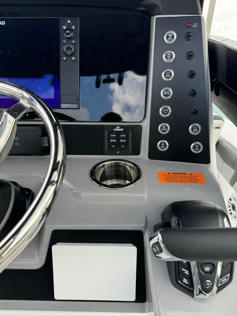 Slide: The Image of 2025 Robalo 246 Cayman boat dashboard with steering wheel and control panel. - 24