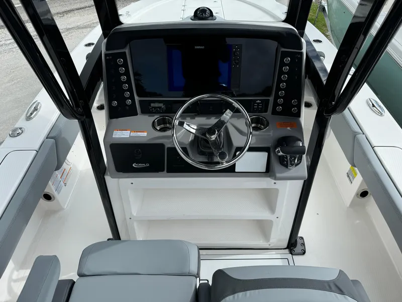 Slide: The Image of 2025 Robalo 246 Cayman boat dashboard with modern controls and steering wheel. - 7
