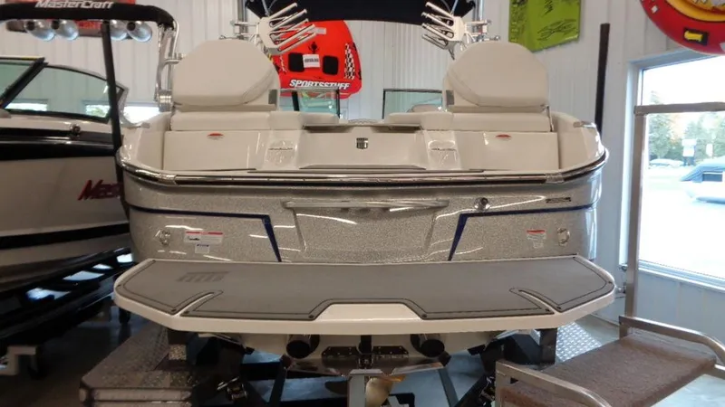 Slide: The Image of 2017 MasterCraft X23 boat in showroom, rear view with swim platform. - 17