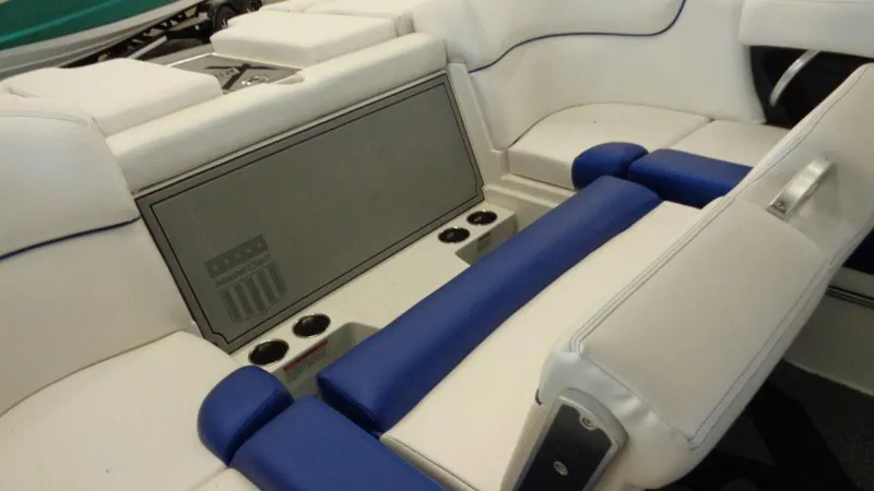 Slide: The Image of 2017 MasterCraft X23 interior with white and blue seating, featuring cup holders and storage. - 2