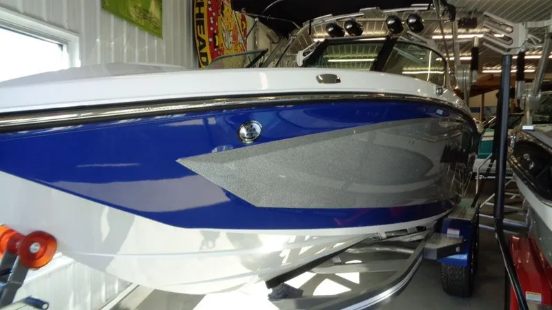 Slide: The Image of 2017 MasterCraft X23 boat with blue and white exterior in showroom. - 27