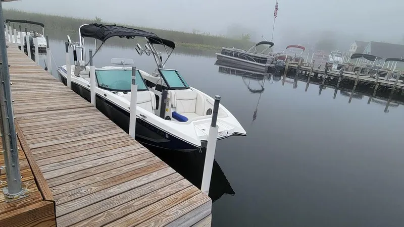 Slide: The Image of 2017 MasterCraft X23 boat docked on a calm, foggy lake. - 32