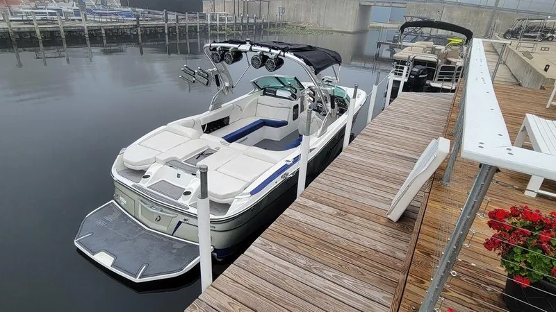 Slide: The Image of 2017 MasterCraft X23 boat docked at a marina, featuring sleek design and spacious seating. - 4