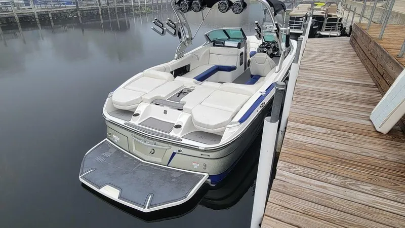 Slide: The Image of 2017 MasterCraft X23 boat docked, featuring spacious seating and sleek design. - 8