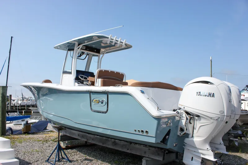 Slide: The Image of 2025 Sea Hunt Ultra 275 SE boat with Yamaha engine, docked outdoors. - 2