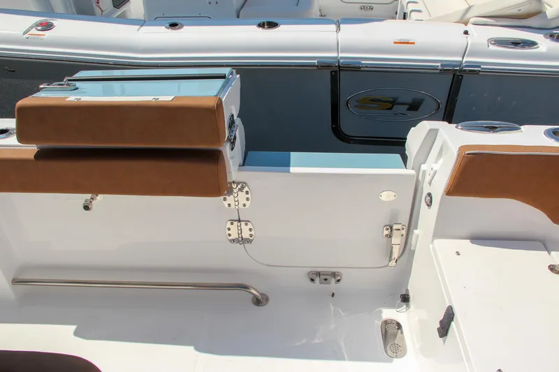 Slide: The Image of 2025 Sea Hunt Ultra 275 SE boat interior with brown seating and stainless steel fixtures. - 24