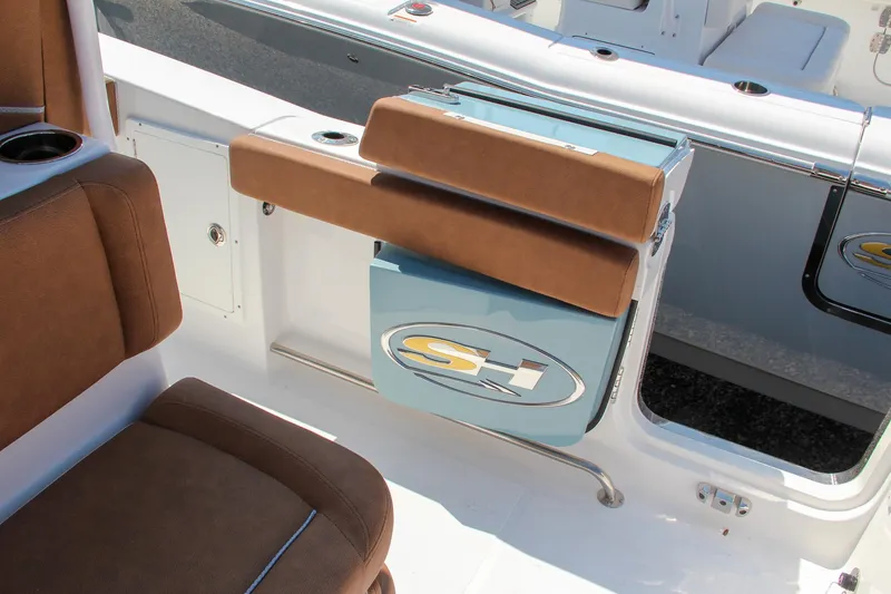 Slide: The Image of 2025 Sea Hunt Ultra 275 SE boat interior with brown seating and storage compartment. - 25