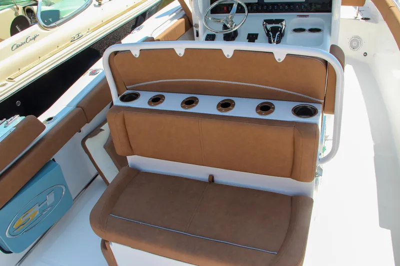 Slide: The Image of 2025 Sea Hunt Ultra 275 SE boat interior with brown seating and cup holders. - 26